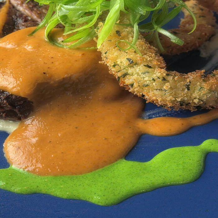 Romesco, herb purée and a panko-crusted onion ring